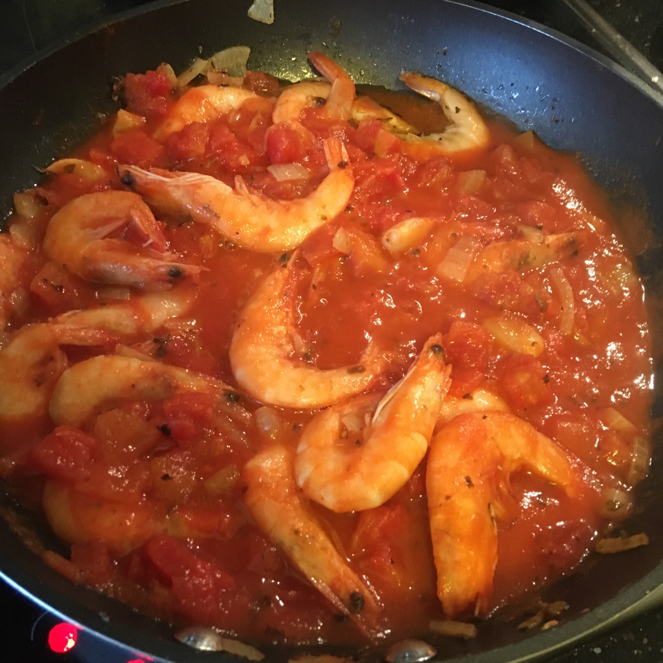 Спагетти по-средиземноморски с королевскими креветками, кусочками томатов и базиликом
