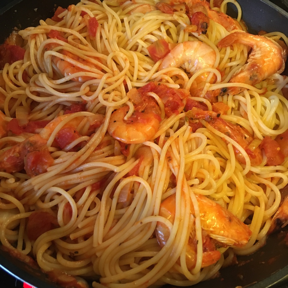 Спагетти по-средиземноморски с королевскими креветками, кусочками томатов и базиликом
